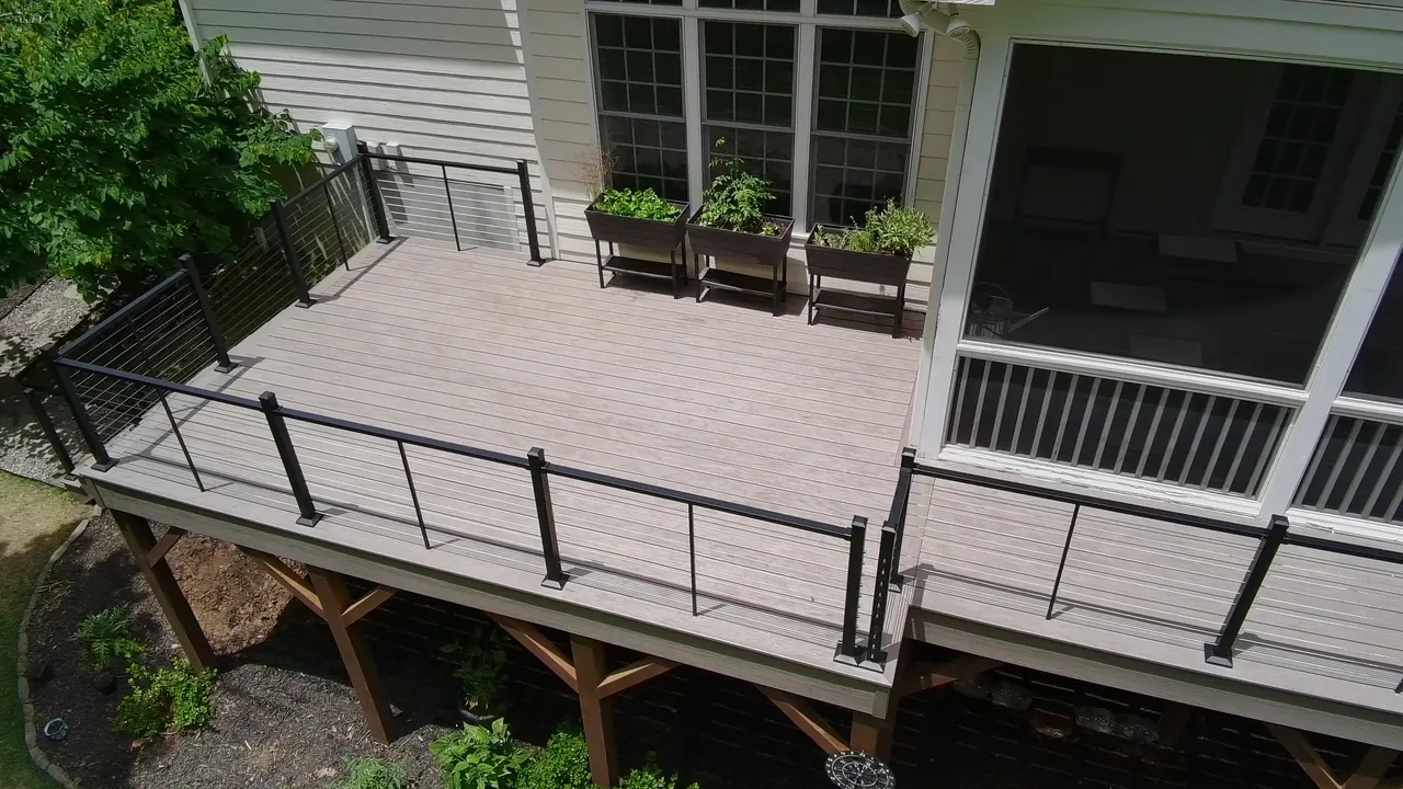 Composite deck with black cable railing and wide steps built by Mission Decks