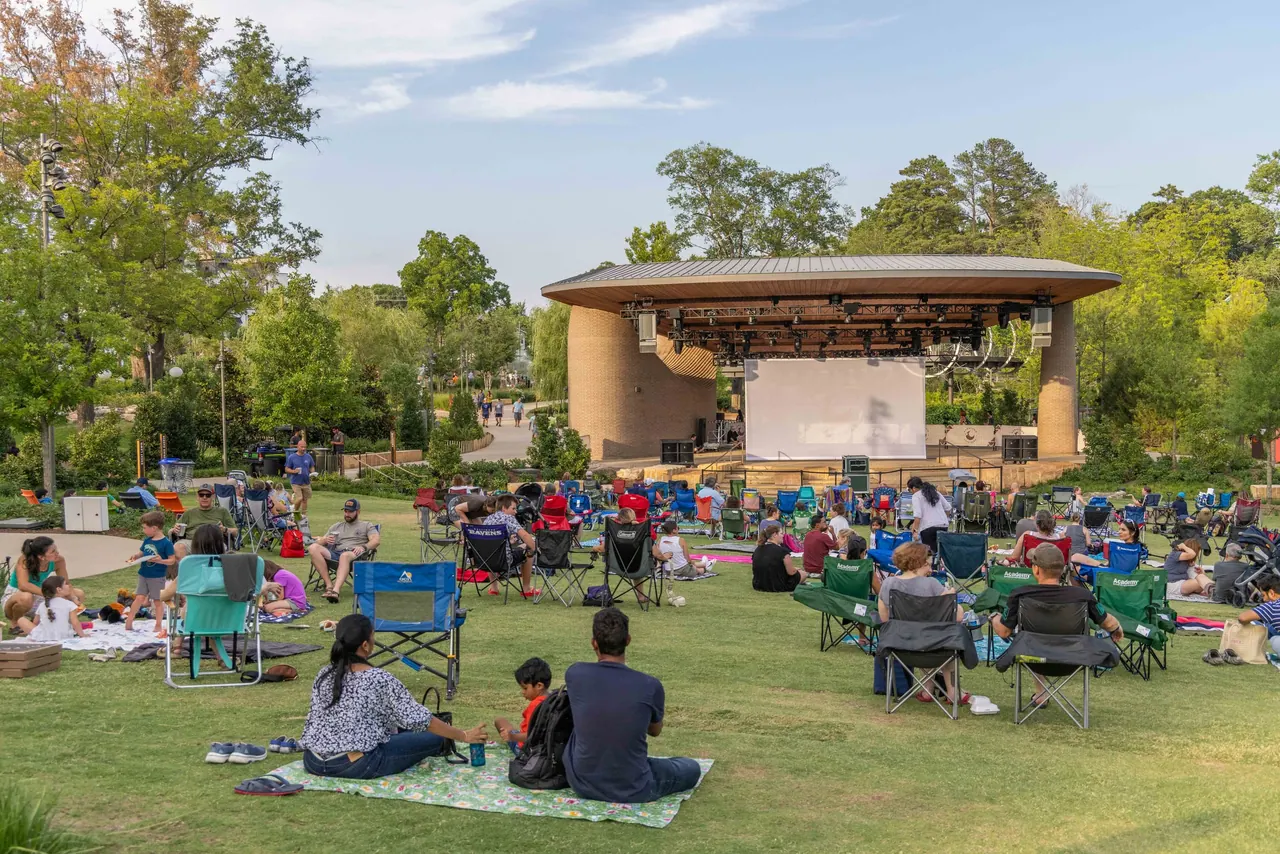 Downtown Cary Park in Cary, North Carolina, with people gathered on the lawn before the amphitheatre