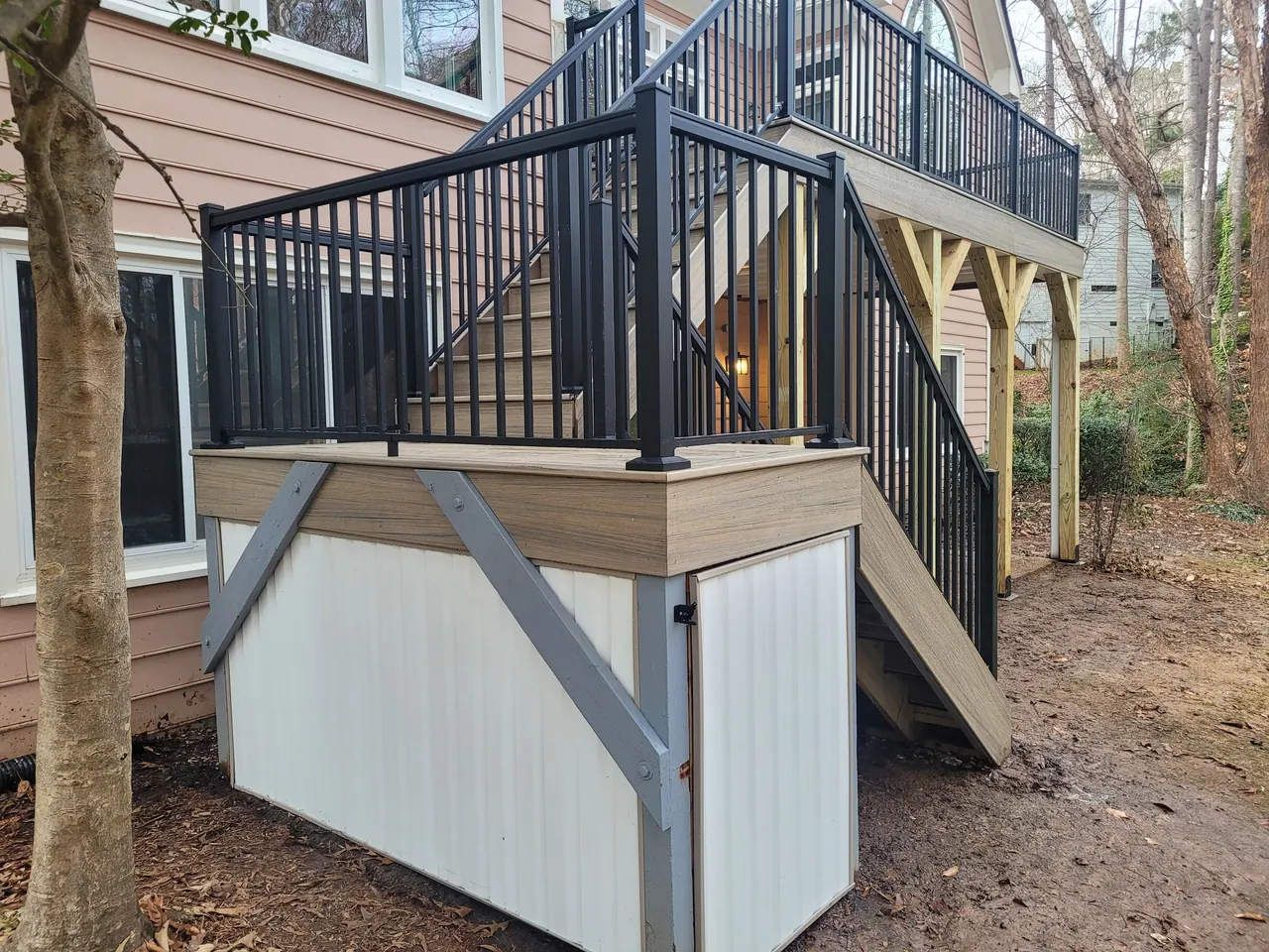 Elevated deck with black aluminum railing above a white under-deck storage enclosure