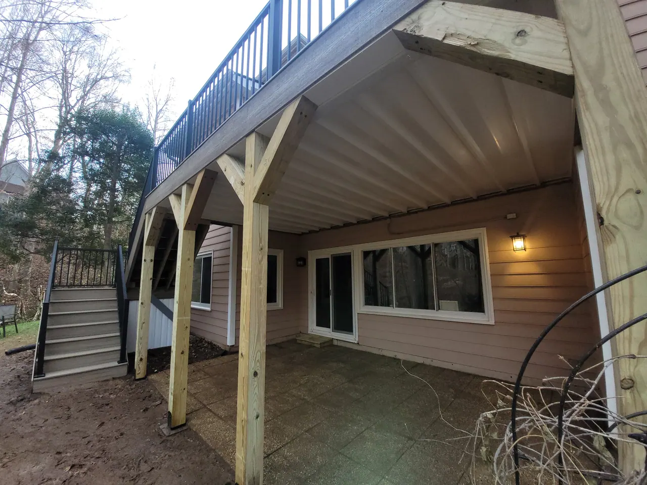 Covered under-deck patio with heavy timber posts and a finished ceiling