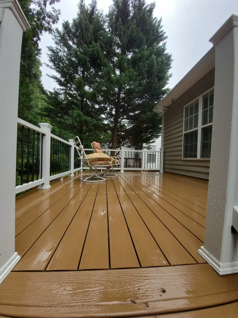 Warm cedar-toned deck boards with white railing beside a screened porch