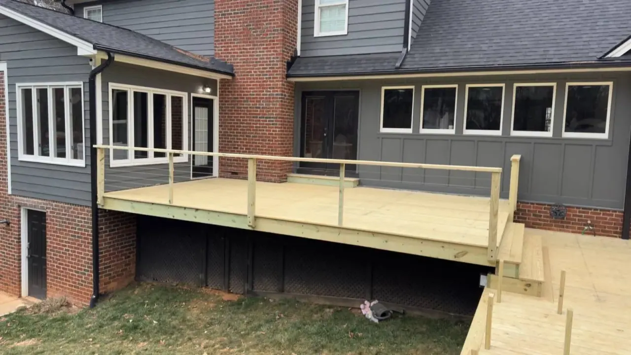 Elevated pressure-treated deck framed above a walk-out basement