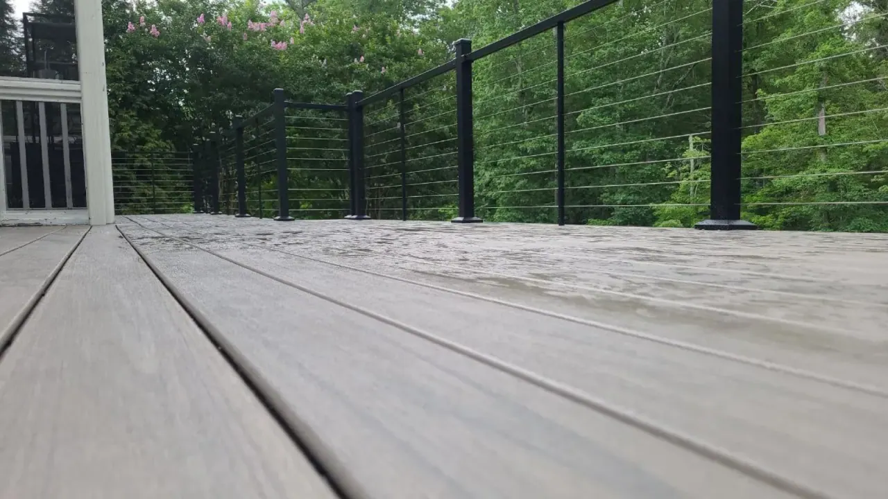 Close detail of composite deck boards running to a cable railing