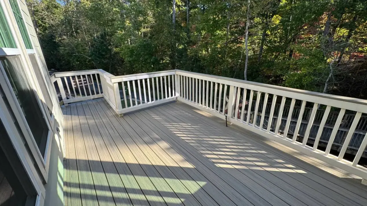 Large composite deck with white picket-style railing and outdoor rug
