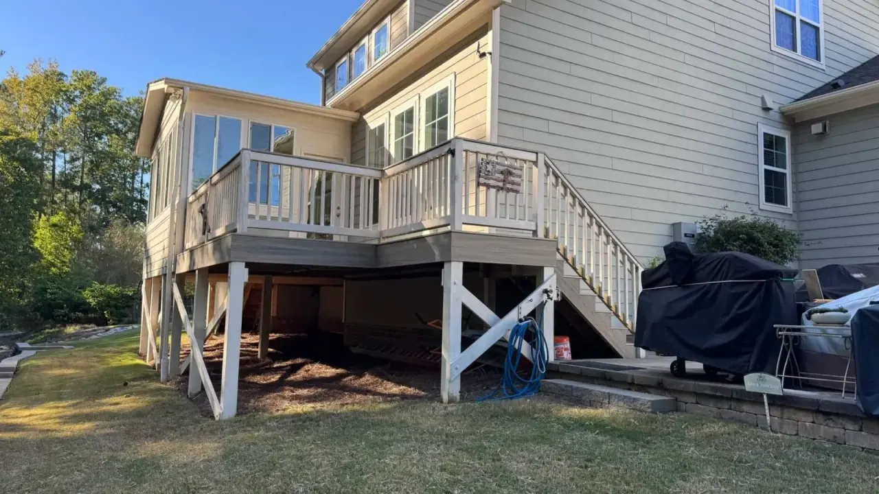 Elevated deck with white support posts and stairs to the lawn
