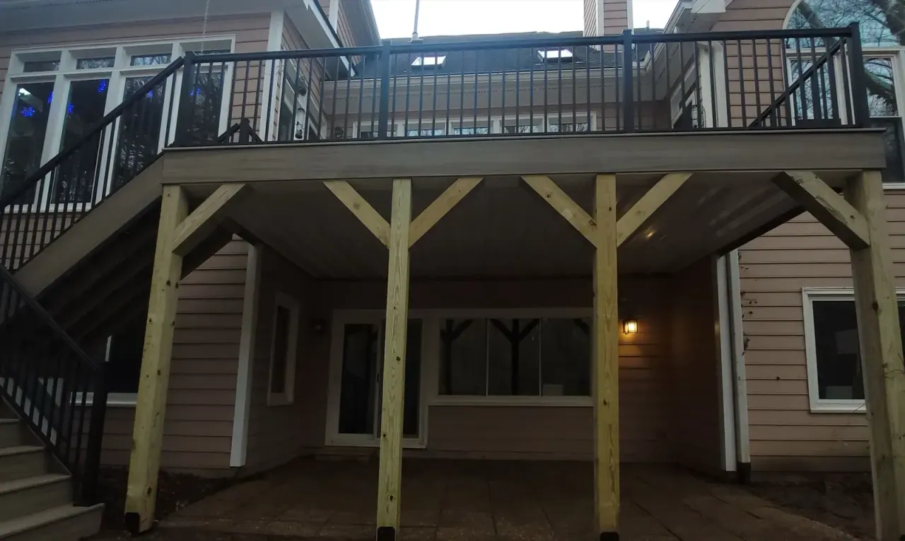 Under-deck living area with heavy timber posts and black railing above