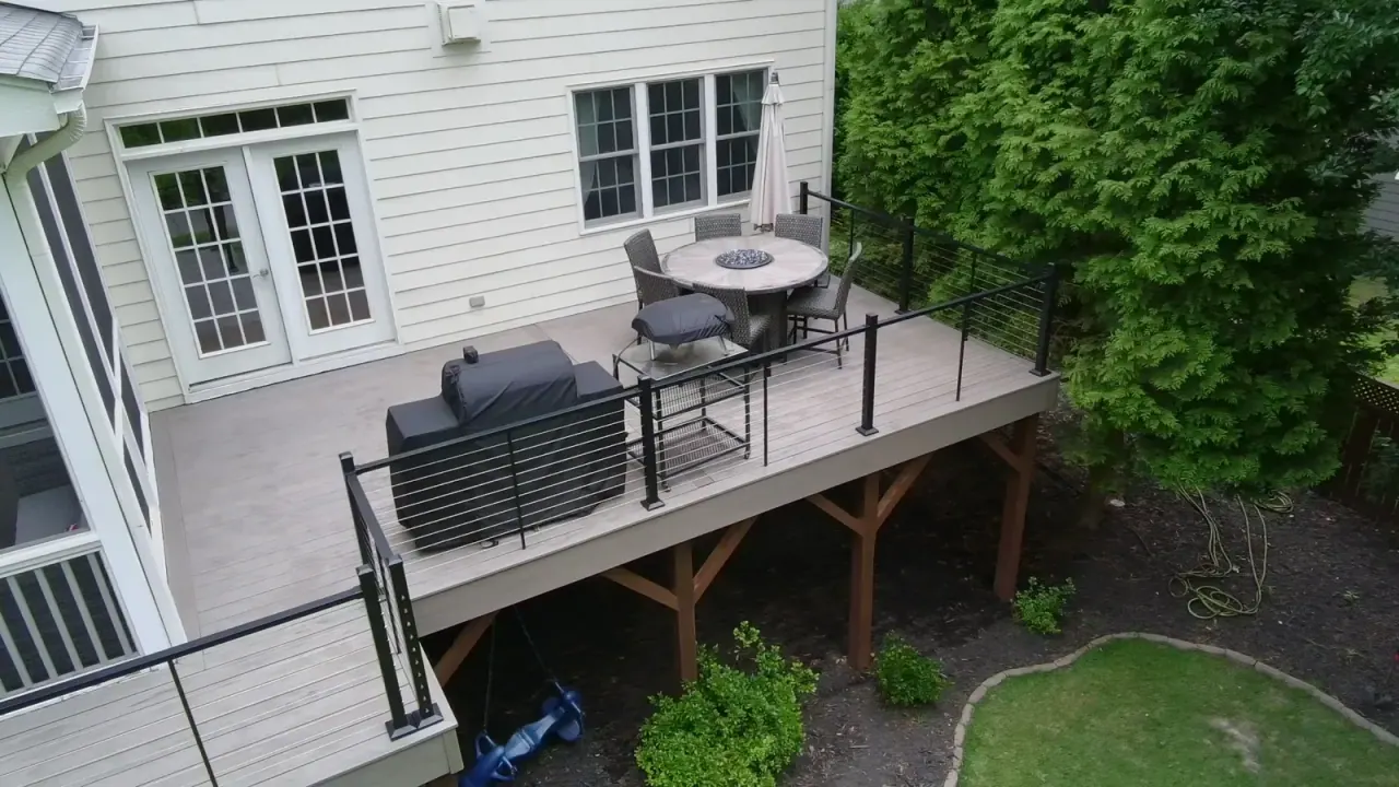 Aerial view of a composite deck with fire table, black railing and timber support posts